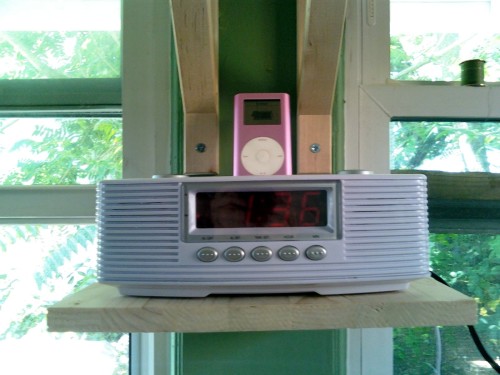 The shelf I made for my clock and ipod player. It was made from left over pieces after I sawed down the shelf planks to fit the windows. I think it is so nice to cook and listen to music.